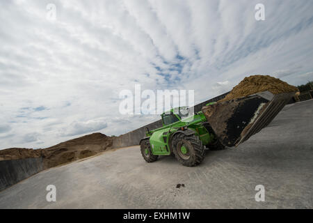 Una pala caricatrice gommata caricata con mais da insilato fa il suo modo attraverso Roemerhuegel impianto di produzione di biogas per alimentare il sistema in Kornwestheim, Germania, 14 luglio 2015. Produttore di Biogas KWA Bioenergie ha depositato un ricorso costituzionale contro la riduzione delle sue entrate attraverso la tedesca Energie Rinnovabili Act (EEG). Foto: Marijan Murat/dpa Foto Stock