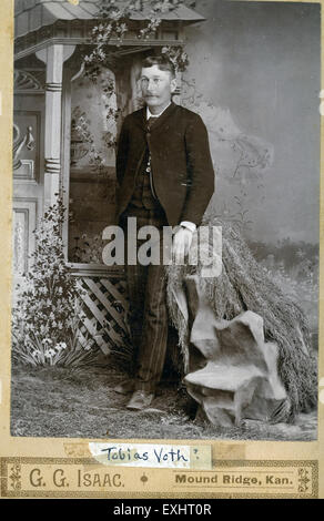 Questa foto raffigura un giovane non identificato di Moundridge, Kansas. Cattura un momento dal passato, anche se si sa poco dell'identità del soggetto. L'immagine evidenzia lo stile del periodo e il modo in cui gli individui sono stati ritratti nella fotografia durante quel periodo. Foto Stock