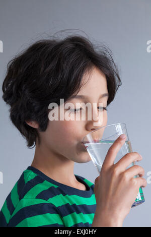Ragazzo adolescente di bere un bicchiere di acqua Foto Stock