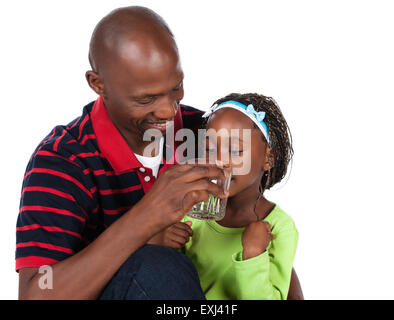 Adorabili piccolo bambino africano con trecce indossando un luminoso camicia verde e blue jeans è con suo padre. Indossa un rosso str Foto Stock