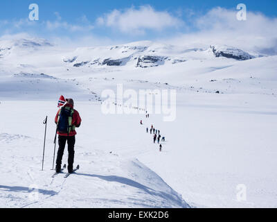 Giornata nazionale il 17 maggio, i Norvegesi a piedi su sci , portando bandiere norvegesi, a piedi da Finse, la più alta stazione ferroviaria su ferrovia Os Foto Stock