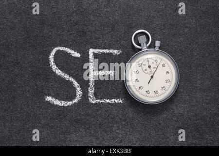 Abbreviazione di SEO concetto manoscritta su lavagna con vintage cronometro preciso utilizzato al posto di o Foto Stock