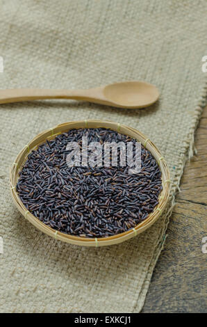 Materie viola Riceberry riso nel cestello di bambù con il cucchiaio di legno Foto Stock