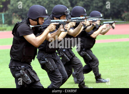 Shanghai, Cina. 14 Luglio, 2015. SWAT team membri della pubblica sicurezza Ufficio di Shanghai Fengxian distretto ricevono una formazione durante un drill in mezzo ad alta temperatura in Shanghai, Cina orientale, luglio 14, 2015. A due mesi di durata SWAT trapano è in corso qui con tale curriculum come cross-country gara con carico pesante, pneumatico-lifting e le tattiche di squadra, anti-attacco combattere e una rapida ripresa. © Fan Jun/Xinhua/Alamy Live News Foto Stock