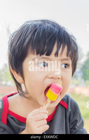 Ritratto di Asian Thai little boy a mangiare il gelato Foto Stock