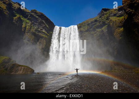 Turista singolo a cascata skogafoss in Islanda Foto Stock