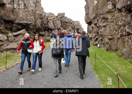 I turisti a piedi attraverso il Almannagja linea anomalia nel mid-atlantic ridge Nord America placca Thingvellir parco nazionale di Islanda Foto Stock