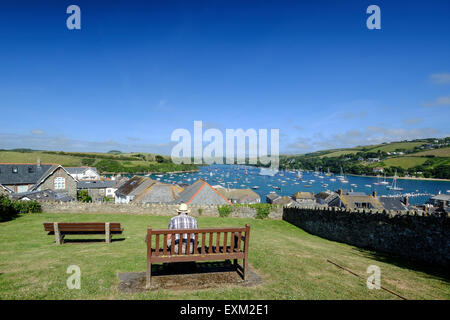 Salcombe, Devon, Regno Unito. Uomo su una panchina godendo della vista di Salcombe da alto fino in città. Foto Stock