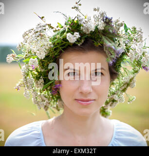 Ritratto di una giovane donna che indossa una corona di fiori di campo estivo Foto Stock