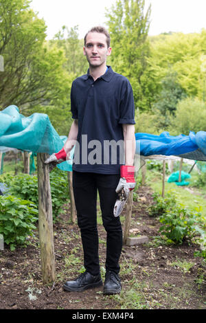 Ufficio lavoratori facendo alcuni volontari lavori di giardinaggio con carriole, Wedding, scavo, in guanti da giardinaggio Foto Stock