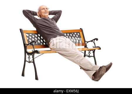 Carefree senior comodamente seduto su una panca in legno e guardando in lontananza isolato su sfondo bianco Foto Stock