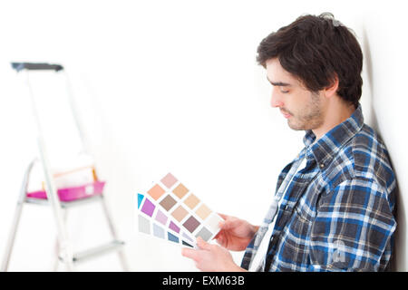 Vista di un attraente uomo scegliendo il colore del suo nuovo flat Foto Stock