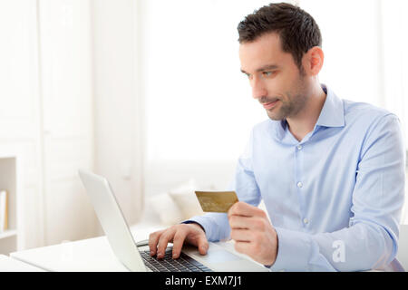 Vista di un giovane uomo di affari di pagare online con carta di credito Foto Stock