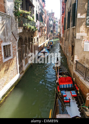 Vista di una gondola ormeggiata in uno stretto canale nella città di Venezia con belle case sui lati. Venezia. L'Italia. Foto Stock