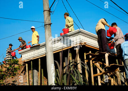 Gli abitanti dei villaggi locali uniscono le forze per lavorare alla costruzione di una nuova casa in java indonesia Foto Stock