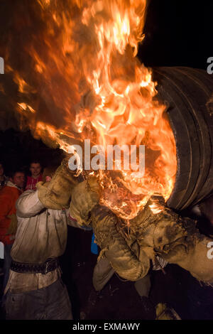 Grandi uomini canna essendo portati attraverso la folla in piazza per contrassegnare notte dei falò, 5 novembre, presso il Tar di barili festival, Flintham, Inghilterra Foto Stock