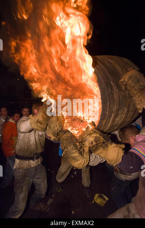 Grandi uomini canna essendo portati attraverso il quadrato per marcare notte dei falò, 5 novembre, presso il Tar di barili festival, Flintham, Inghilterra Foto Stock