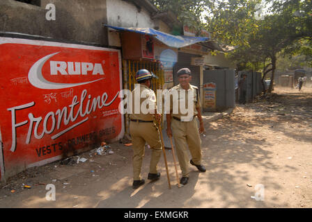 Il personale di polizia pattuglia quando rivoltosi rompere i vetri dei veicoli Bhandup comunità Dalit resort violente proteste Mumbai Foto Stock