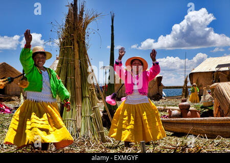 Due donne indigene sventolando la fotocamera sull'isola di Uros, il lago Titicaca, Perù, Sud America. Foto Stock