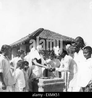 Il Mahatma Gandhi ; Durga Mehta e altri in un tulsi la piantagione di alberi cerimonia al Sevagram Ashram ; 1946 n. MR Foto Stock