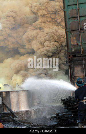 Vigili del fuoco personale o i vigili del fuoco nel tentativo di spegnere un incendio in contenitori di prodotti chimici a Mulund in Mumbai Bombay Foto Stock