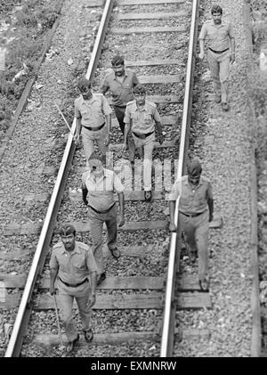 Poliziotti a camminare su binari ferroviari di Mumbai India Maharashtra Foto Stock
