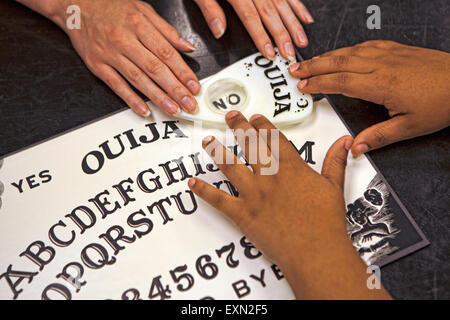 In prossimità di due teenager le mani giocando con una Ouija Board. Foto Stock