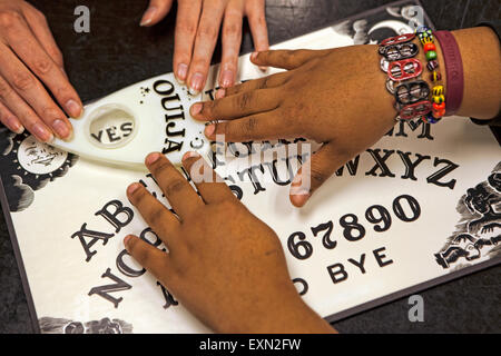 In prossimità di due teenager le mani giocando con una Ouija Board. Foto Stock