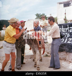 Ein kleiner Junge beim Eselreiten am Strand Las Salinas auf Ibiza, Ibiza 1976. Un ragazzino cavalcando un asino presso la spiaggia di Las Salinas sull'isola di Ibiza, Ibiza 1976. Foto Stock