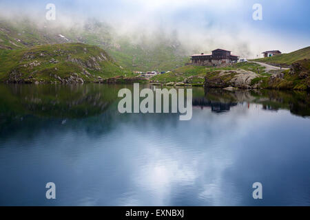 Lago BALEA, Romania - 24 giugno 2012: visione idilliaca con tipici lodge sul lago Balea shore in montagna Fagaras, Romania. Foto Stock