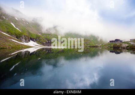 Lago BALEA, Romania - 24 giugno 2012: visione idilliaca con tipici lodge sul lago Balea shore in montagna Fagaras, Romania. Foto Stock