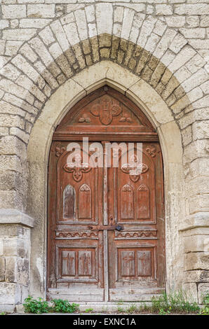 Chiusa antica weathered arcuata di porta della chiesa Foto Stock