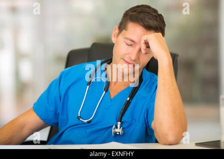 Stanco medical lavoratore seduto in ufficio Foto Stock