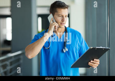 Professional medico parlando al telefono cellulare in ospedale Foto Stock