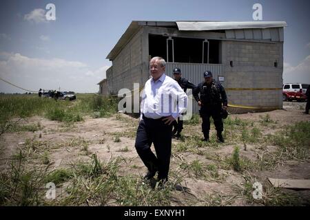 Almoloya de Juarez, Messico. Il 15 luglio 2015. Il Messico per la Sicurezza Nazionale Comissioner Monte Rubido Alejandro Garcia (anteriore) sorge nei dintorni della presunta casa dove fu costruito il tunnel, attraverso il quale può uscire dal carcere del Messico signore di droga Joaquin 'El' Chapo Guzman, in Almoloya de Juarez Mexico, alla periferia di Città del Messico, il 15 luglio 2015. Guzman, leader di Sinaloa drug cartello, scomparso dalla massima sicurezza prigione Altiplano al di fuori della Città del Messico Sabato notte, secondo la commissione per la sicurezza nazionale. (Xinhua/Alejandro Ayala) Credito: Xinhua/Alamy Li Foto Stock