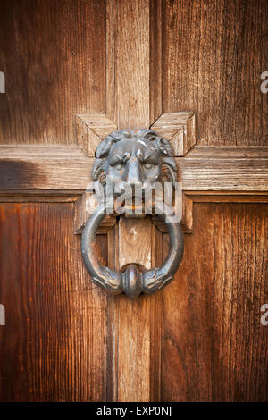 Vecchio masaneta in forma di testa di leone con anello su vintage porta in legno Foto Stock