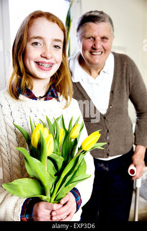 La nipote con un bouquet di fiori con sua nonna, Germania Foto Stock