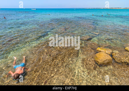PORTOPALO, Italia - 19 agosto 2014: i turisti e i locali godono di mare blu sull Isola delle Correnti beach a Portopalo, Sicilia Foto Stock
