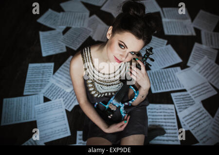 Ragazza in posa e tenendo un violino Foto Stock