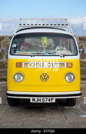 St Ives, Cornwall, Regno Unito: Giallo VW camper van con "Chill Out' segno sulla parte anteriore, parcheggiato in St Ives, Cornwall. Foto Stock