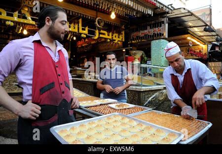 Damasco, Siria. 16 Luglio, 2015. Siri di preparare il cibo in un mercato a monte del Eid al-Fitr festa a Damasco, Siria, 16 luglio 2015. Eid al-Fitr, chiamato anche festa di rompere il digiuno è un importante festa religiosa celebrata dai musulmani in tutto il mondo, che segna la fine del Ramadan, islamica del sacro mese del digiuno. © Ammar/Xinhua/Alamy Live News Foto Stock