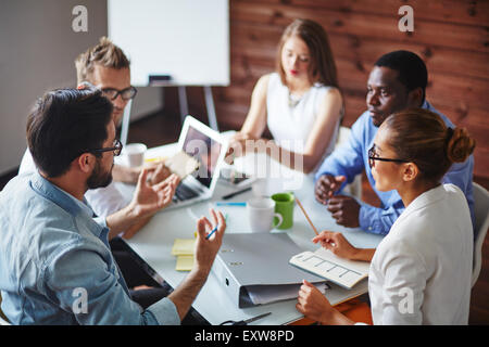 Gruppo di multi-etnico business partner per discutere le idee Foto Stock