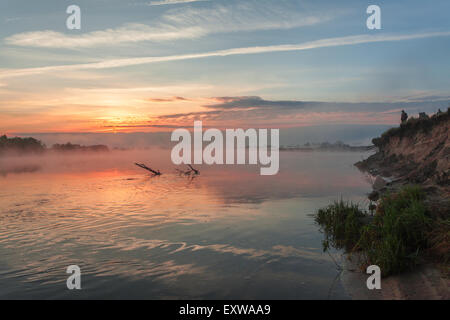 La riflessione dei primi raggi del sole all'alba nel lago Foto Stock