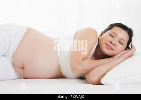 Donna incinta sdraiato sul lato e il sonno, Foto Stock