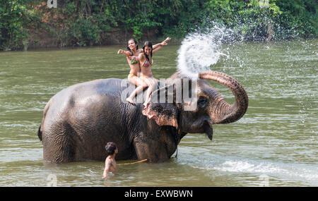 Irrorazione di elefante due turisti con acqua, la Provincia di Kanchanaburi, Tailandia Centrale, Thailandia Foto Stock