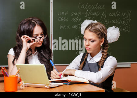 Si torna a scuola. Il tartaro della lezione. Il maestro controlla la soluzione allo studente. Il concetto di istruzione moderna. Foto Stock