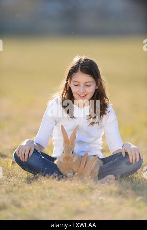 Ragazza con il suo coniglio su un prato Alto Palatinato, Baviera, Germania, Europa Foto Stock