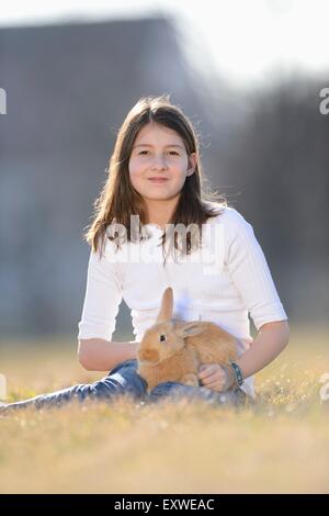 Ragazza con il suo coniglio su un prato Alto Palatinato, Baviera, Germania, Europa Foto Stock