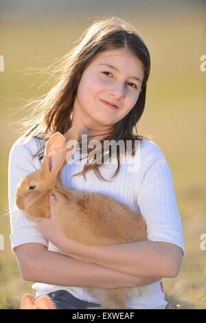 Ragazza con il suo coniglio su un prato Alto Palatinato, Baviera, Germania, Europa Foto Stock