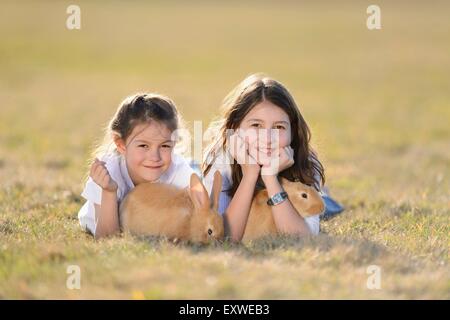 Due bambini con il suo coniglio su un prato Alto Palatinato, Baviera, Germania, Europa Foto Stock